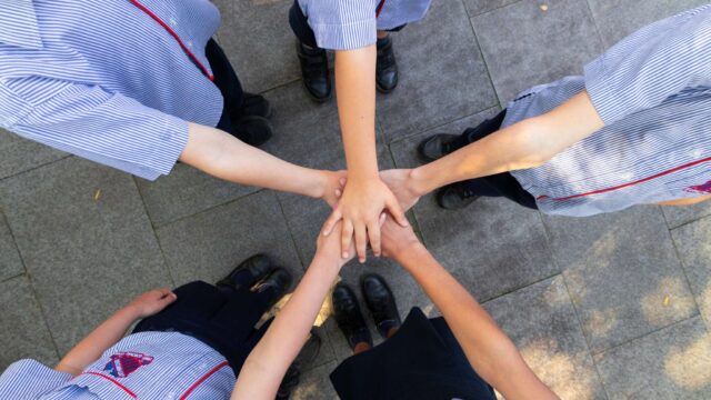 Students hands linked